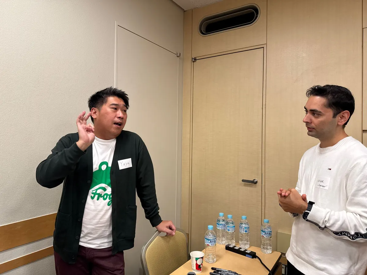 交流会で、身振りを交えて話すFrogメンバーと参加者